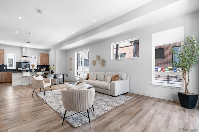 living area with light wood-style floors, recessed lighting, and baseboards