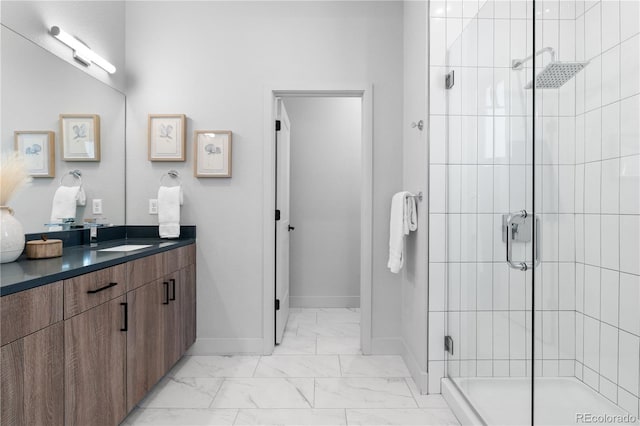 bathroom with marble look tile flooring, a stall shower, baseboards, and vanity