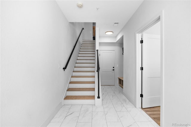 stairs with marble finish flooring and baseboards