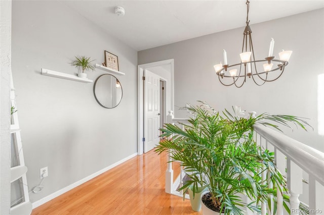 hallway featuring hardwood / wood-style flooring and an inviting chandelier