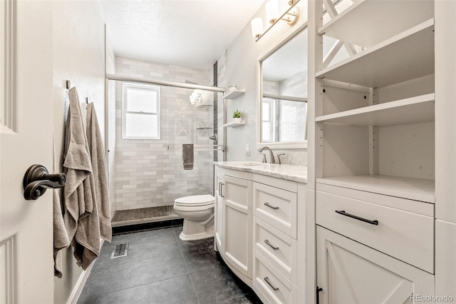 bathroom featuring vanity, toilet, a healthy amount of sunlight, and a shower with door