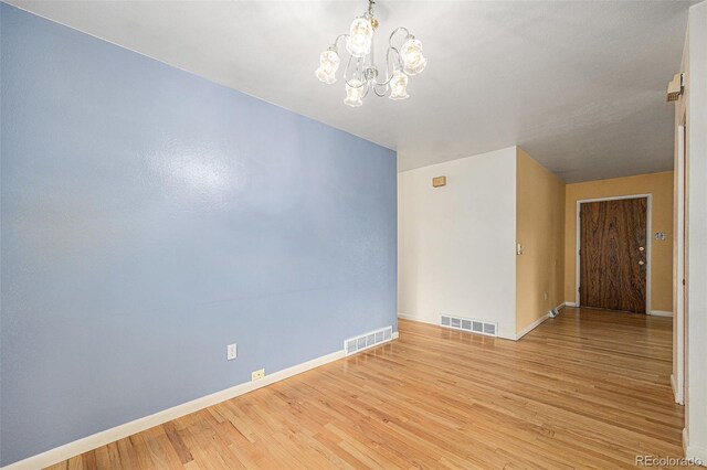 5502 E Center Ave, Denver, CO 80246 - unfurnished room featuring a chandelier and light wood-style flooring