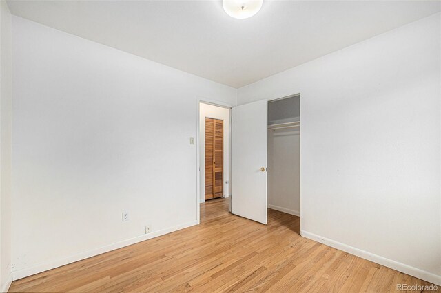 5502 E Center Ave, Denver, CO 80246 - unfurnished bedroom featuring light wood-style floors and a closet