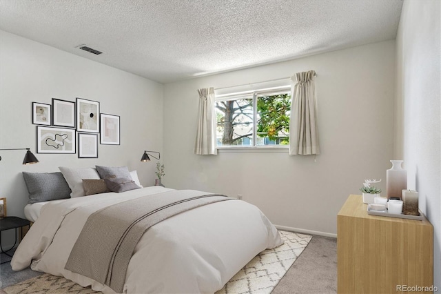 7275 S Gaylord St Unit I09, Littleton, CO 80122 - bedroom featuring light colored carpet, a textured ceiling, and baseboards
