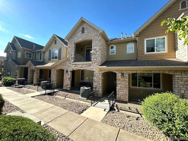 11207 Osage Cir Unit B, Northglenn, CO 80234 - view of front of house with a porch, a balcony, stone siding, and central AC unit