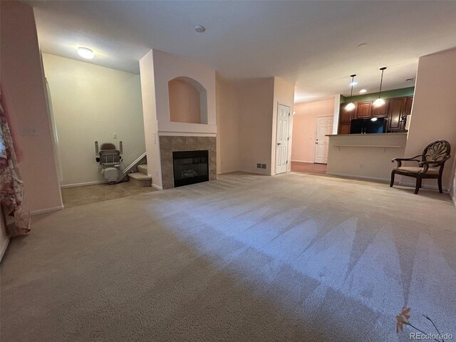 11207 Osage Cir Unit B, Northglenn, CO 80234 - unfurnished living room with light colored carpet, a tile fireplace, and baseboards