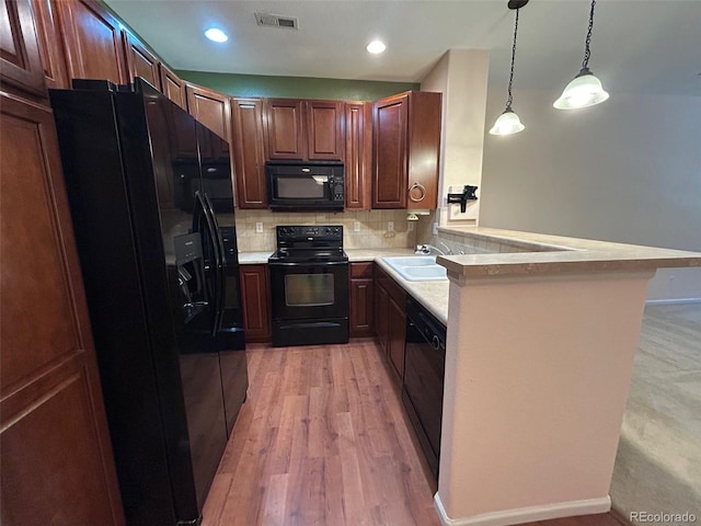 11207 Osage Cir Unit B, Northglenn, CO 80234 - kitchen with black appliances, a sink, light countertops, tasteful backsplash, and a peninsula