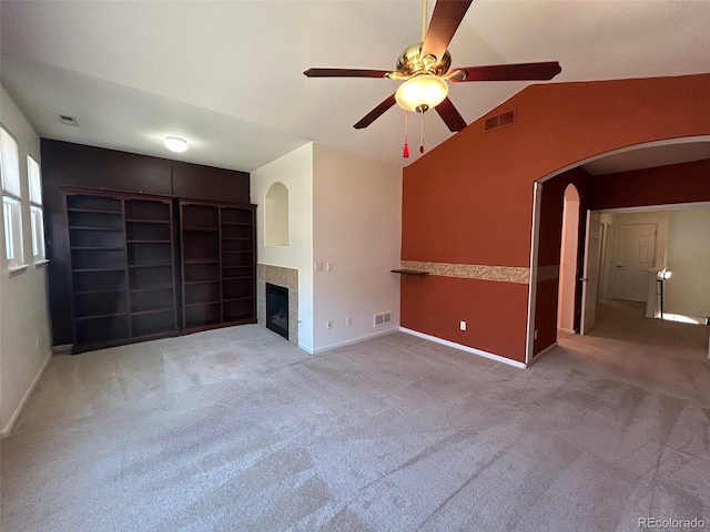 11207 Osage Cir Unit B, Northglenn, CO 80234 - unfurnished living room featuring arched walkways, a ceiling fan, vaulted ceiling, a tiled fireplace, and baseboards