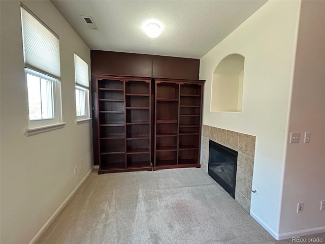 11207 Osage Cir Unit B, Northglenn, CO 80234 - unfurnished living room featuring a fireplace, baseboards, carpet, and a textured ceiling