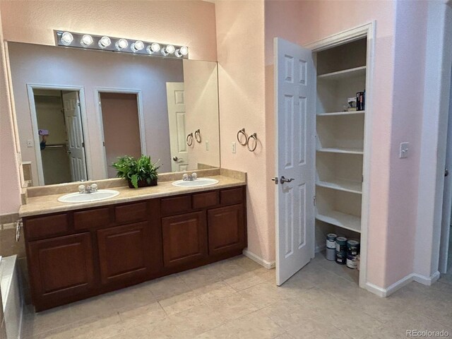 11207 Osage Cir Unit B, Northglenn, CO 80234 - full bathroom featuring double vanity, tile patterned flooring, and baseboards