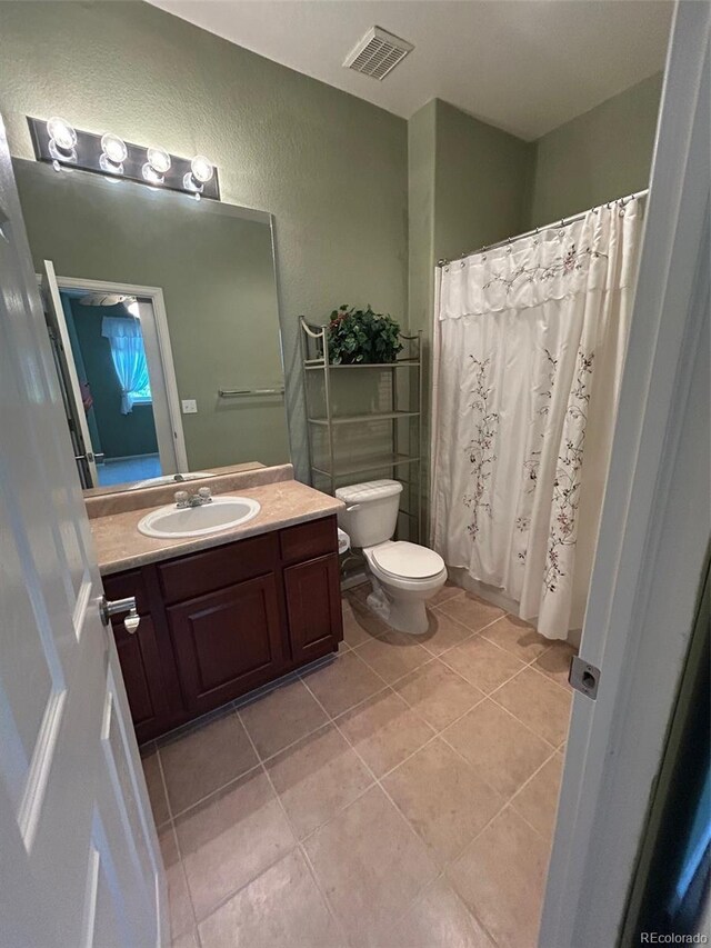 11207 Osage Cir Unit B, Northglenn, CO 80234 - full bathroom featuring tile patterned flooring, toilet, vanity, a textured wall, and a shower with shower curtain