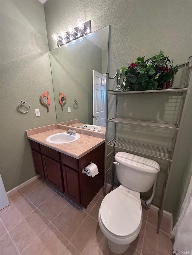 11207 Osage Cir Unit B, Northglenn, CO 80234 - bathroom featuring vanity, toilet, a textured wall, tile patterned floors, and baseboards