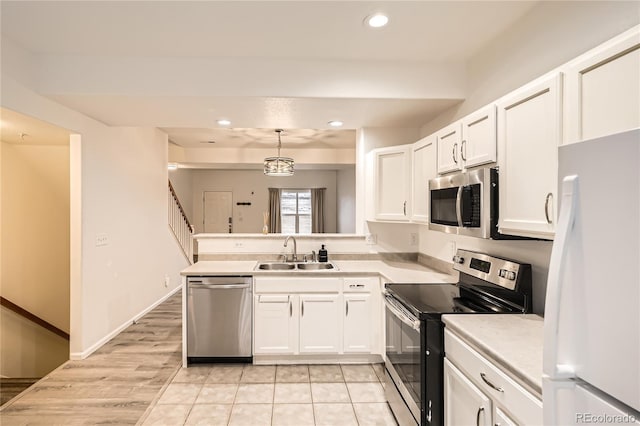 kitchen with white cabinetry, sink, hanging light fixtures, kitchen peninsula, and stainless steel appliances