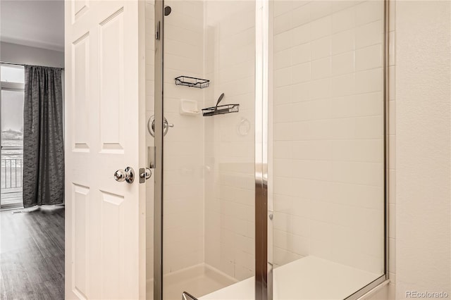 bathroom with walk in shower and hardwood / wood-style floors