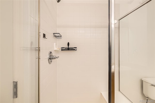 bathroom featuring an enclosed shower and toilet