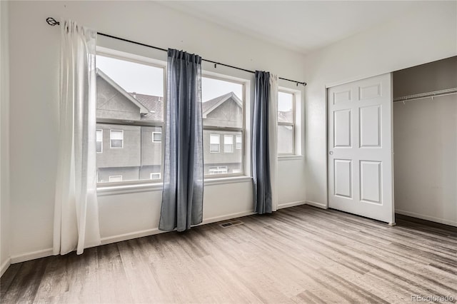 unfurnished bedroom with a closet and light wood-type flooring