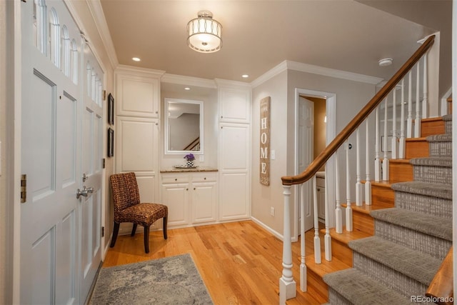 foyer featuring recessed lighting, baseboards, stairs, light wood-style floors, and crown molding