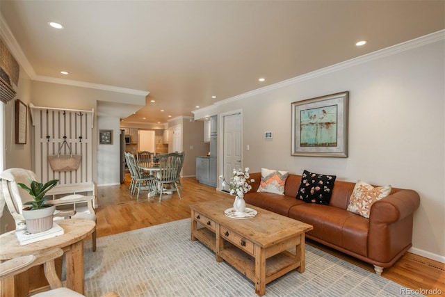 living room featuring ornamental molding and light hardwood / wood-style flooring