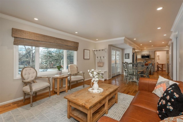 living room featuring ornamental molding, recessed lighting, light wood-style flooring, and baseboards