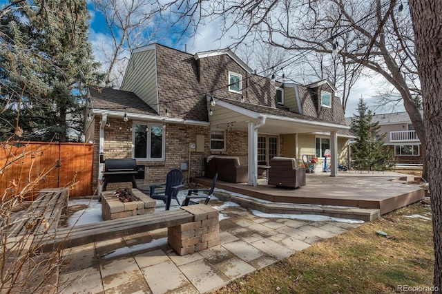 back of property featuring an outdoor fire pit, roof with shingles, fence, a patio area, and brick siding