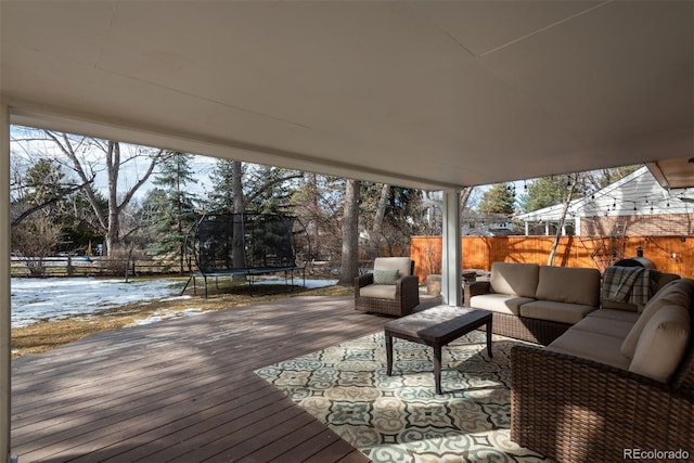 snow covered deck with a trampoline and an outdoor living space