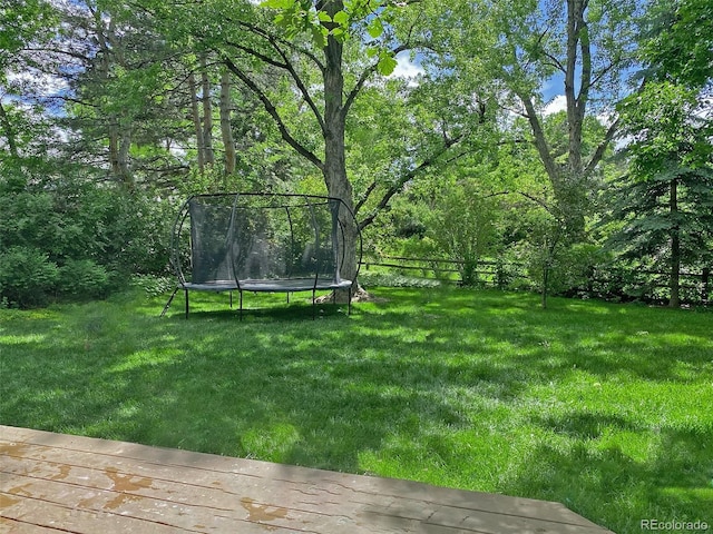 view of yard with a trampoline and fence