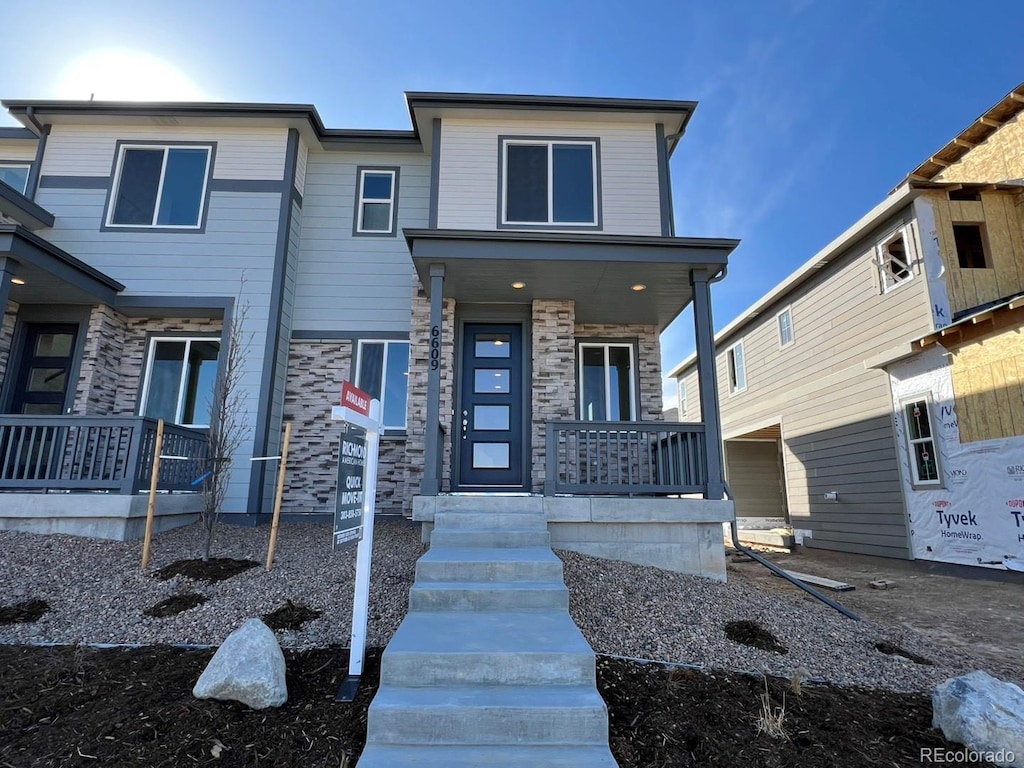 view of front of home with stone siding and a porch