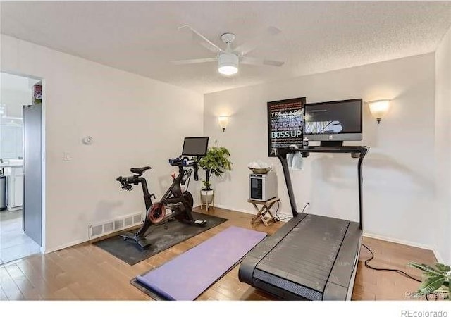 workout area with wood-type flooring and ceiling fan