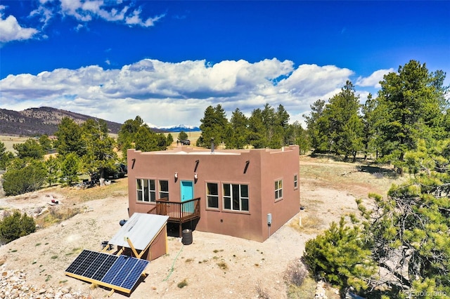 147 Sulky Ct, Hartsel, CO 80449 - rear view of house featuring solar panels, stucco siding, and a mountain view