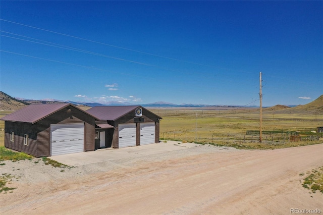 147 Sulky Ct, Hartsel, CO 80449 - view of front of house featuring a detached garage, an outbuilding, a view of countryside, and a mountain view