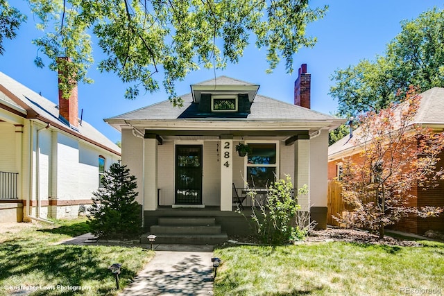 284 S Lafayette St, Denver, CO 80209 - view of front of home featuring brick siding, a porch, a front yard, and a chimney