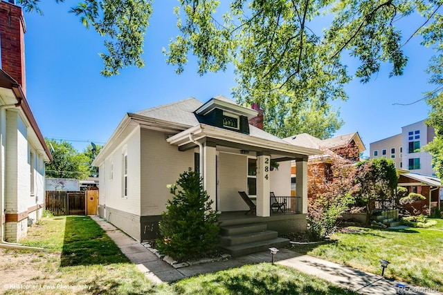 284 S Lafayette St, Denver, CO 80209 - view of front of house with covered porch, a chimney, brick siding, and roof with shingles