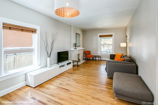 284 S Lafayette St, Denver, CO 80209 - living area with light wood-style flooring, baseboards, and a chandelier