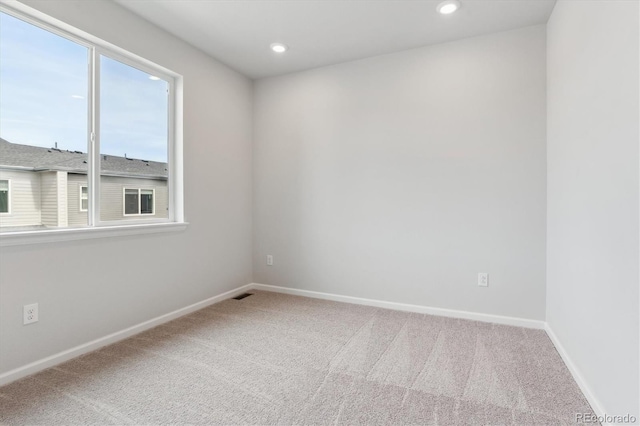 carpeted spare room with baseboards, visible vents, and recessed lighting