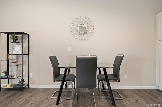 dining room with dark hardwood / wood-style flooring and a chandelier