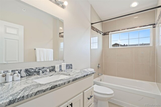 full bathroom with toilet, vanity, and tiled shower / bath