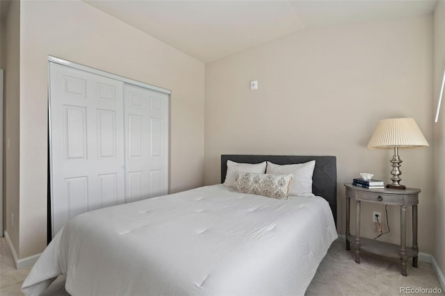 carpeted bedroom featuring lofted ceiling and a closet