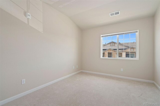 empty room featuring carpet flooring and lofted ceiling