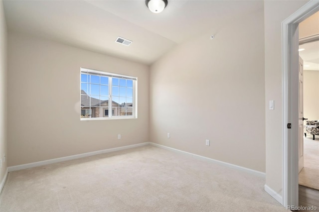 unfurnished room with lofted ceiling and light carpet