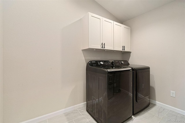 clothes washing area with washer and dryer and cabinets