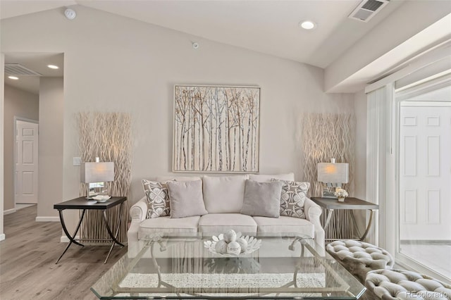 living room featuring light wood-type flooring and vaulted ceiling