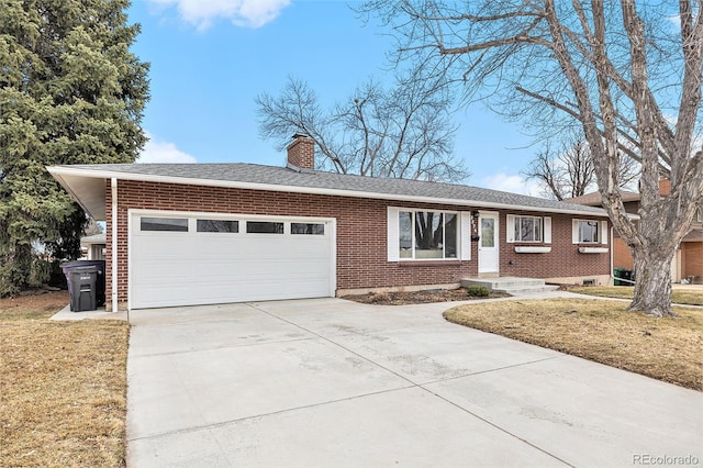 ranch-style home featuring an attached garage, driveway, a chimney, and brick siding