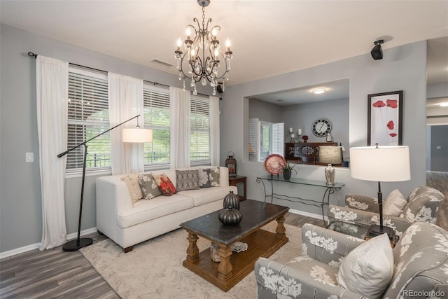 living room featuring a wealth of natural light, hardwood / wood-style floors, and an inviting chandelier