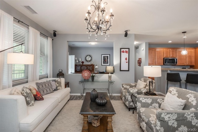 living room with a notable chandelier and light wood-type flooring