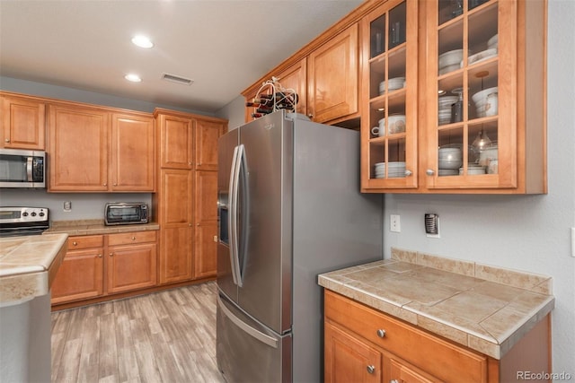 kitchen with light wood-type flooring and appliances with stainless steel finishes