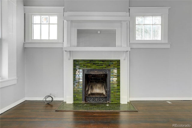 unfurnished living room with dark hardwood / wood-style flooring and a tile fireplace