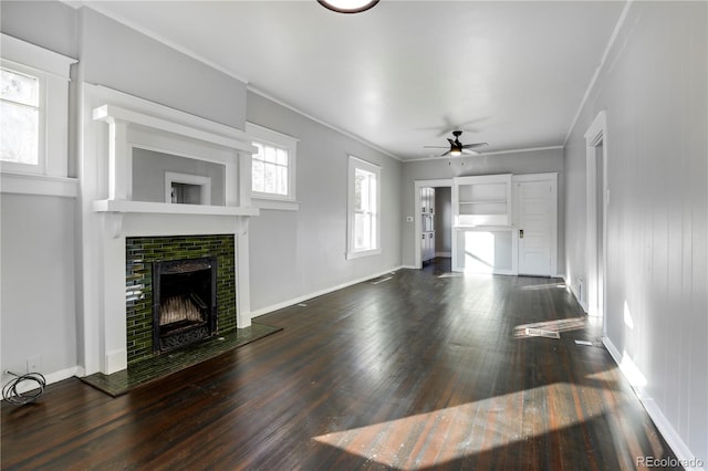 unfurnished living room featuring dark hardwood / wood-style flooring, ceiling fan, and crown molding