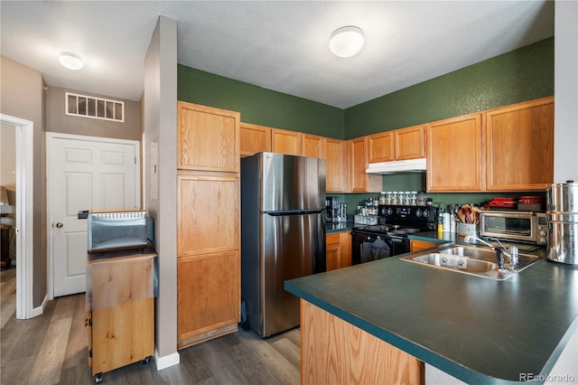 2428 W 82nd Pl Unit 2D, Westminster, CO 80031 - kitchen with freestanding refrigerator, black electric range, under cabinet range hood, a peninsula, and dark wood-type flooring