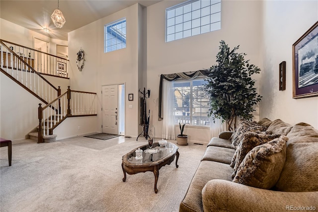 living room with carpet flooring, plenty of natural light, and a high ceiling