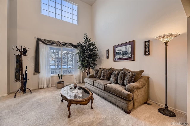 living room with carpet flooring, a high ceiling, and plenty of natural light